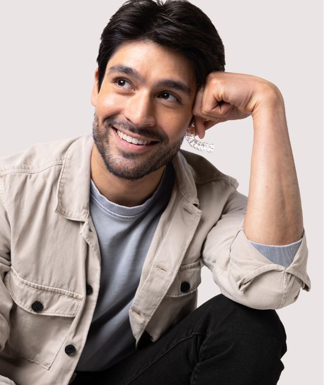 Man smiling while holding a Chomper Labs night guard.