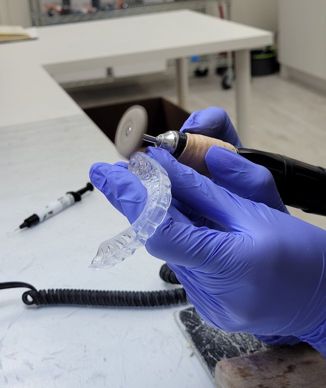 Chomper Labs lab technician polishing night guard.