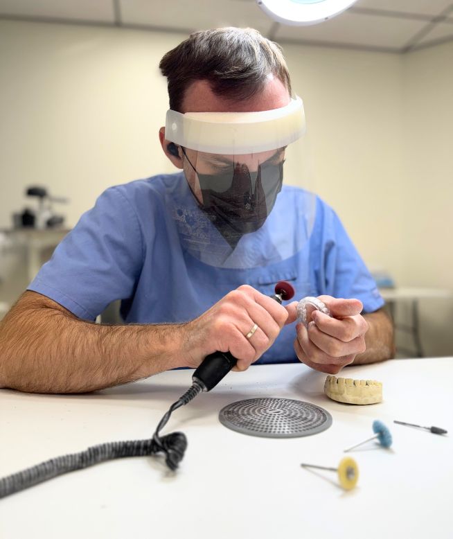 Dental lab technician polishing a night guard.