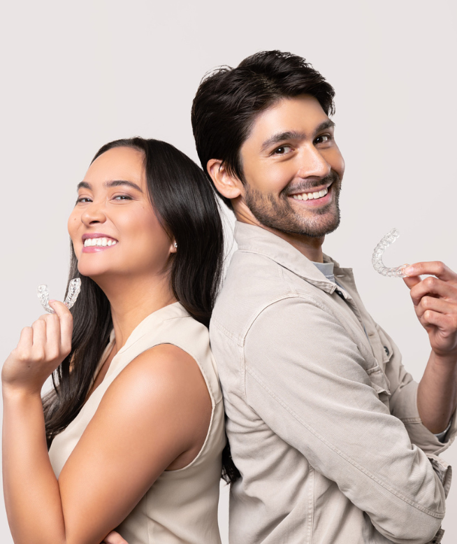 Woman and man smiling and holding Chomper Labs night guards.